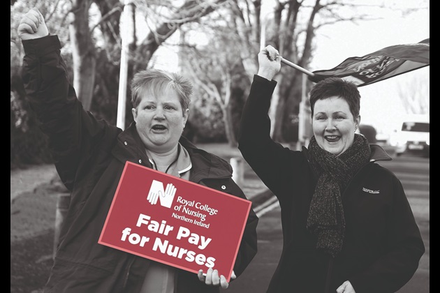 Two members in Northern Ireland hold a fair pay for nursing placard