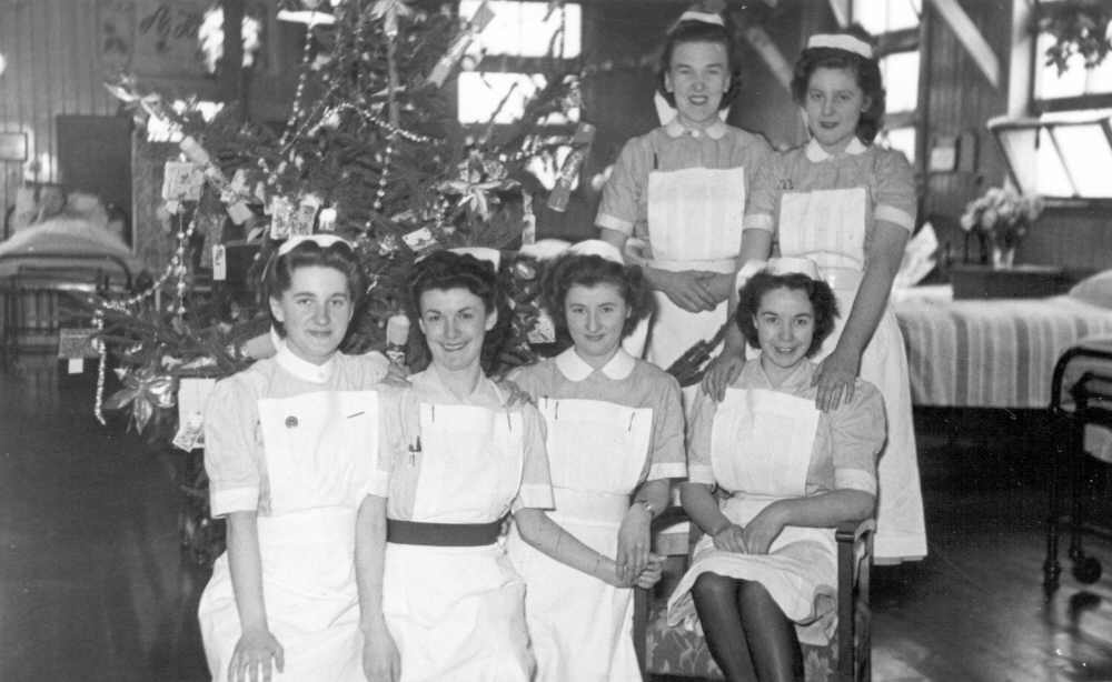 A group of nurses in front of the Christmas tree