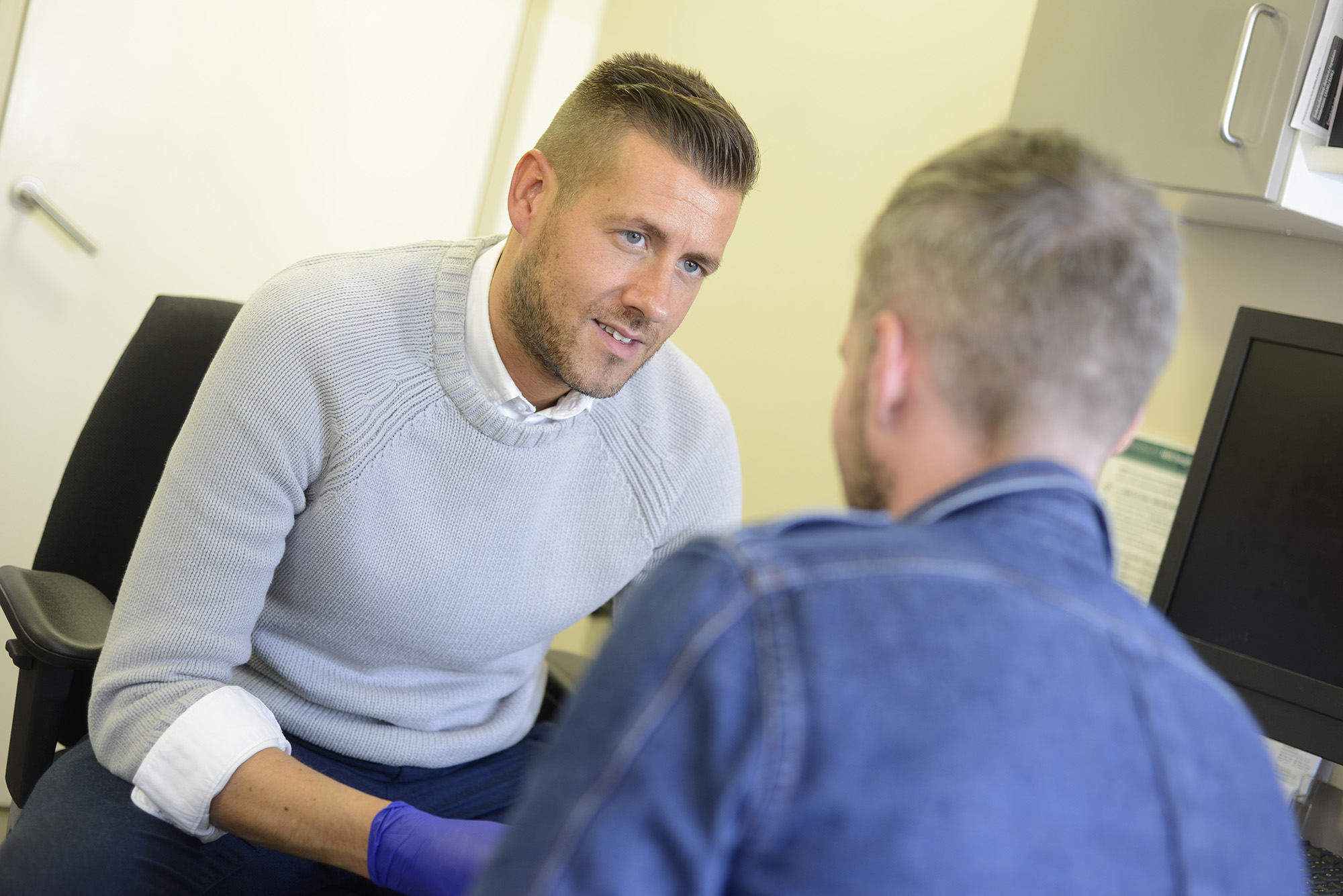 Charge nurse Jon Clarke performs an HIV test on a patient