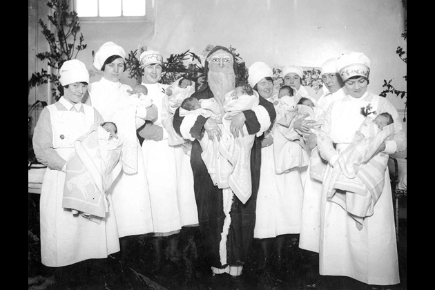 Santa and nurses hold babies on a maternity ward