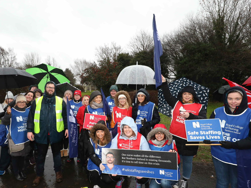 group on picket line with umbrellas