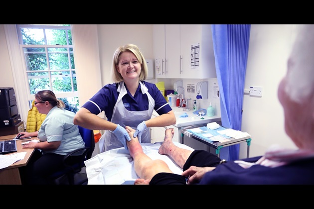 Emma Williamson tends to a patient's lower leg. She has won an RCNi Nurse Award for her work establishing a holistic wound care clinic