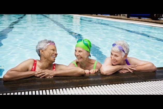 Three women look happy while relaxing in a swimming pool