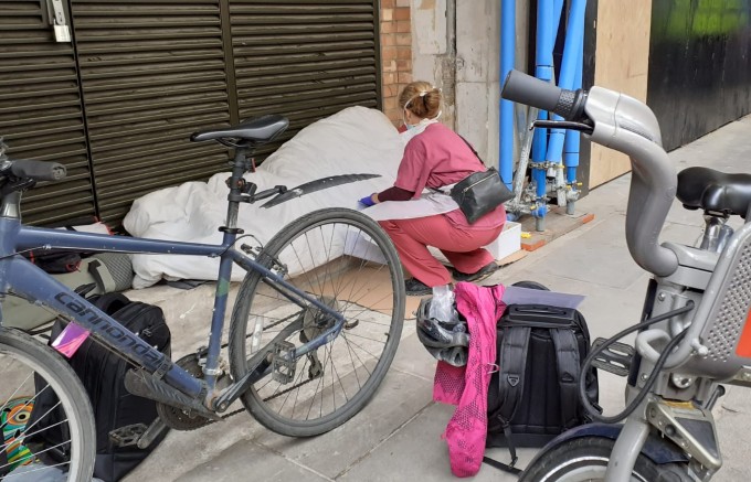 A homeless health nurse from the Westminster Street Nurse programme speaks to a patient on a London street