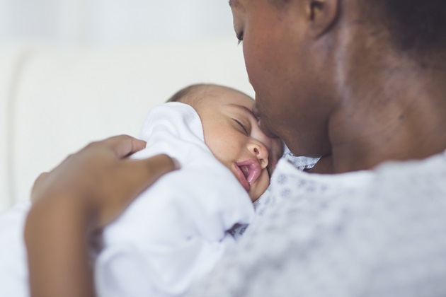 Black mother with newborn in hospital bed