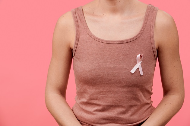 Woman in sleeveless t shirt with breast cancer awareness pink ribbon