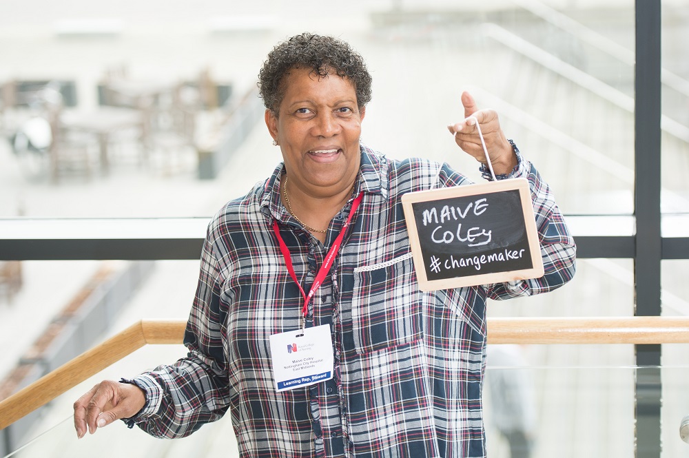 Maive Coley holding a sign