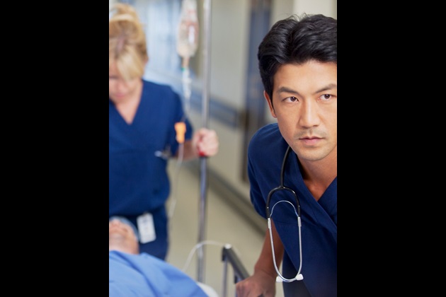 Nursing staff push a patient in a hospital bed
