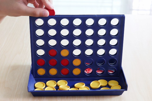 photo shows hand inserting counter into a connect 4 game