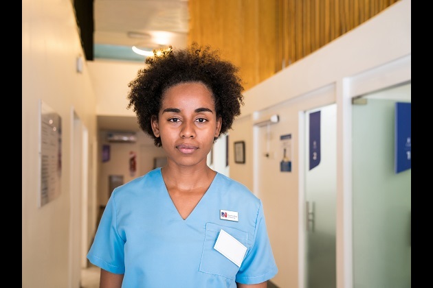 A mixed race nurse staring at the camera