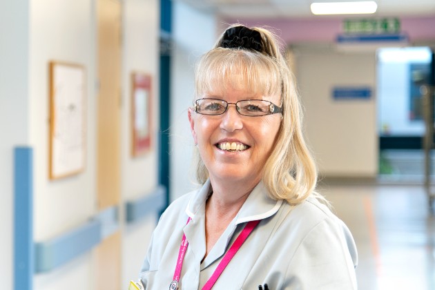 Photo of HCA Tracy Snipp in uniform standing in an empty hospital corridor