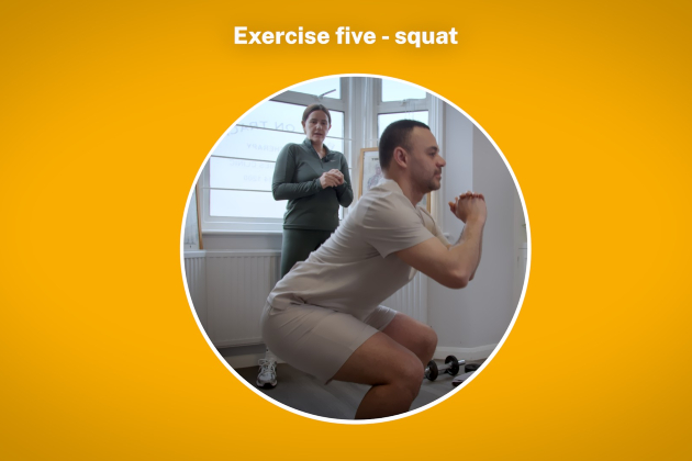 Person crouched in a squat position being watched over by a physiotherapist instructing them