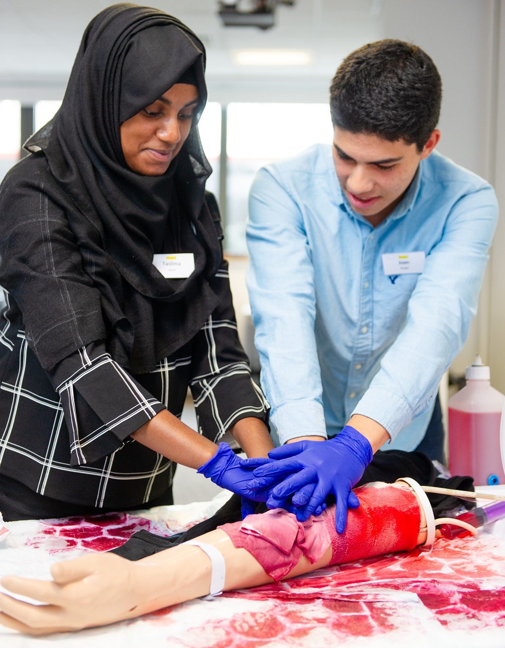 two young people giving heart compressions