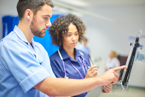 Two nurses reviewing information on a device