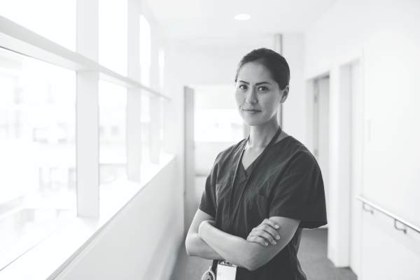 Black and white image of a nurse looking to camera with arms folded