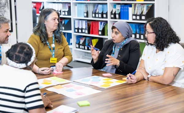 Group of members sitting talking around a table