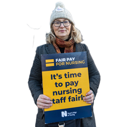 A nurse holding a fair pay for nursing sign