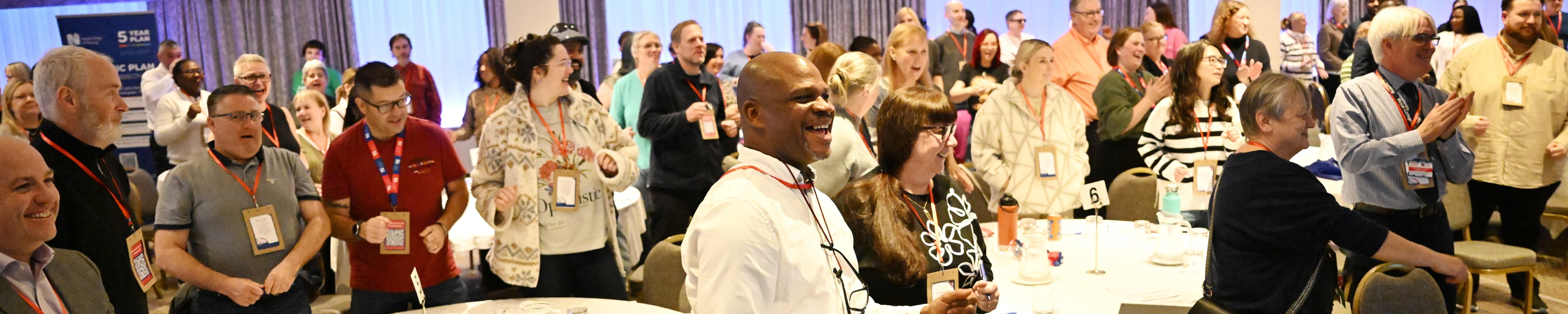 People standing up and clapping in a conference