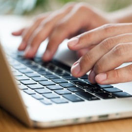 Computer with hands typing