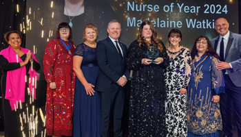 Madelaine Watkins RCN Wales Nurse of the Year 2024 winner photo on stage at awards ceremony Madelaine Watkins winner of RCN Wales Nurse of the Year 2024 group photo with VIPs and award sponsor