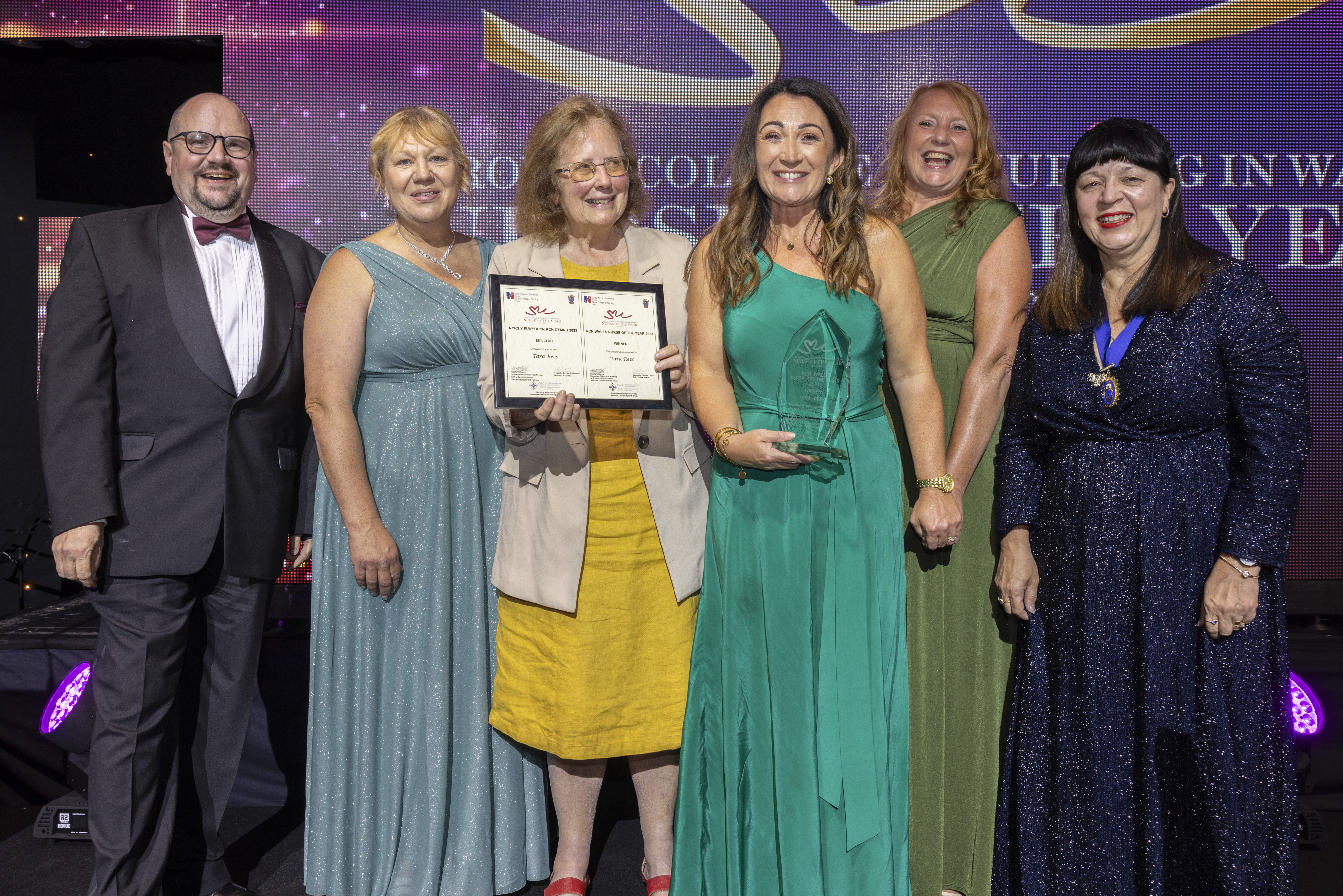 Tara Rees RCN Wales Nurse of the Year 2023 winner photo on stage at awards ceremony Tara Rees winner of RCN Wales Nurse of the Year 2023 group photo with VIPs and award sponsor
