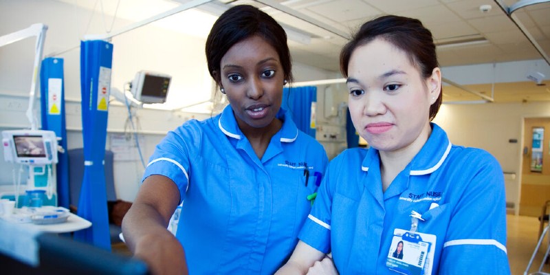Two nursing staff looking at computer