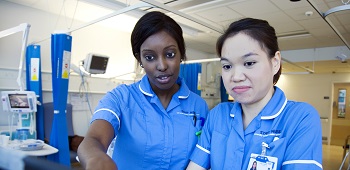 Two nurses looking at a laptop screen